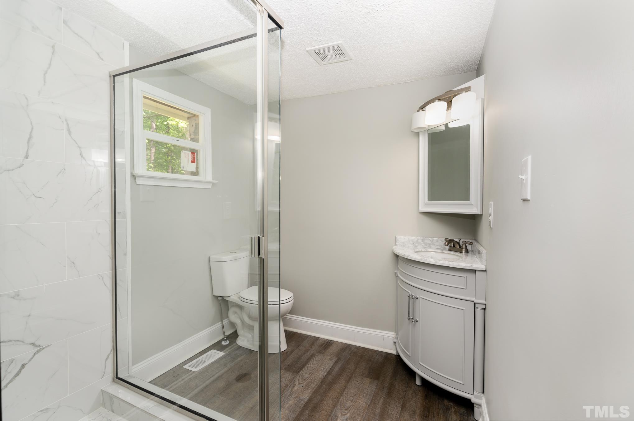 1510 Axum Road Garner, NC 27529 - Photo 13 of 22 a bathroom with a toilet a sink and mirror