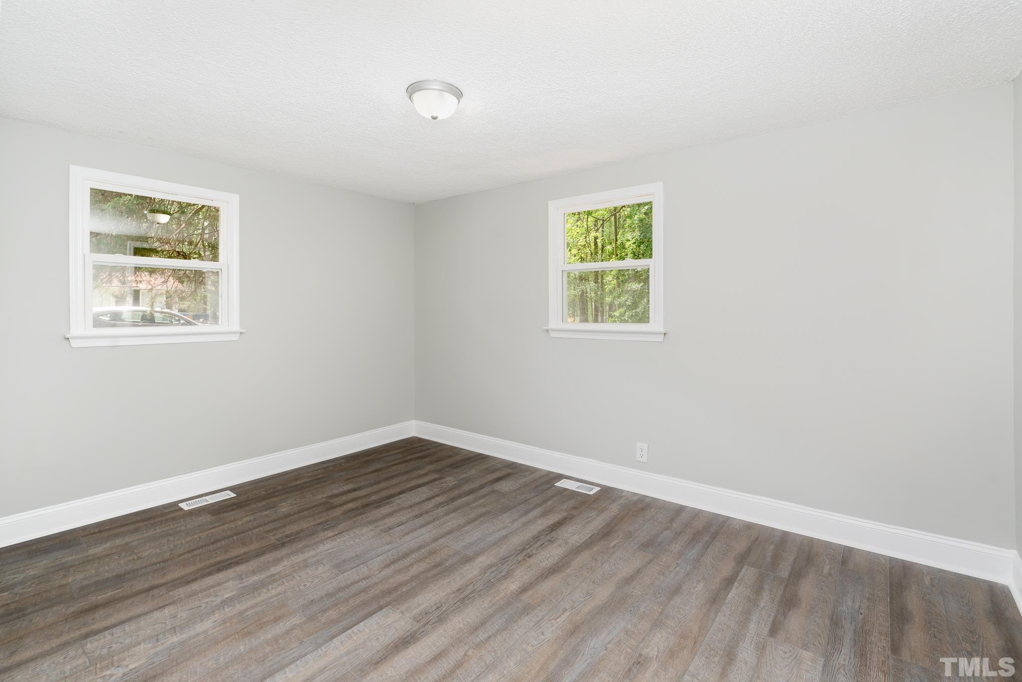 1510 Axum Road Garner, NC 27529 - Photo 17 of 22 an empty room with wooden floor and windows