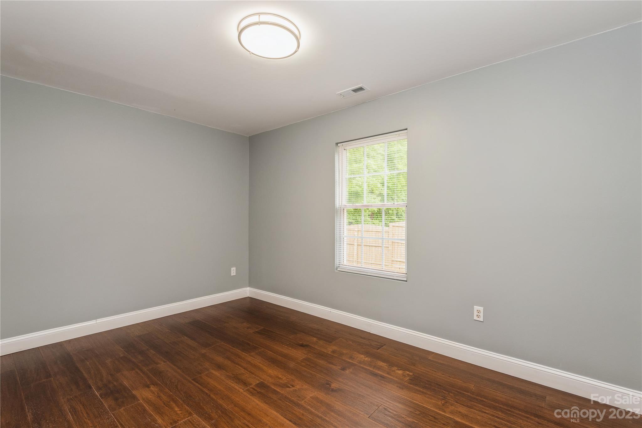 125 Rhyne Station Road Charlotte, NC 28214 - Photo 17 of 26 an empty room with wooden floor and windows