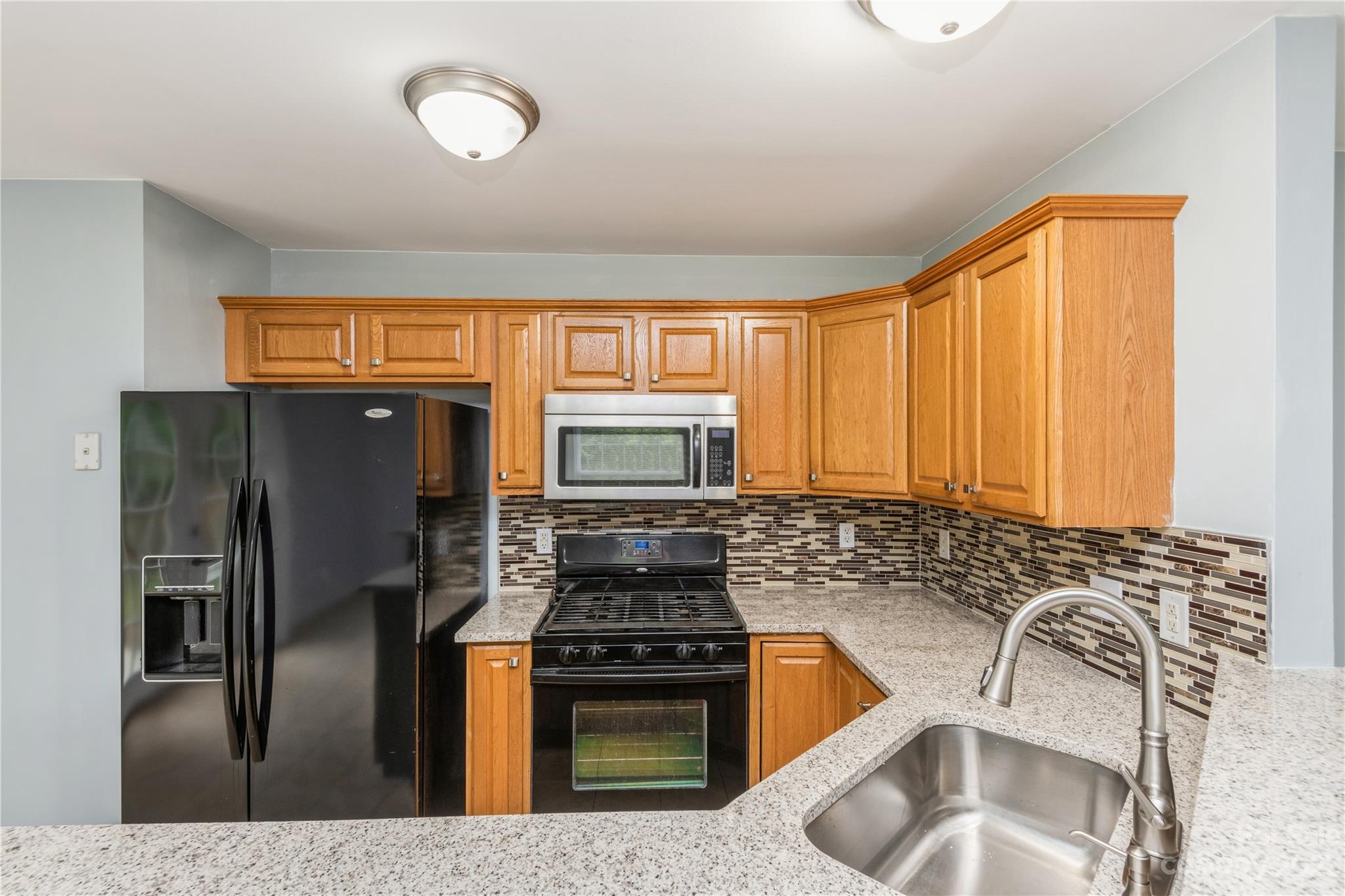 125 Rhyne Station Road Charlotte, NC 28214 - Photo 9 of 26 a kitchen with stainless steel appliances granite countertop a refrigerator a stove a sink and a microwave