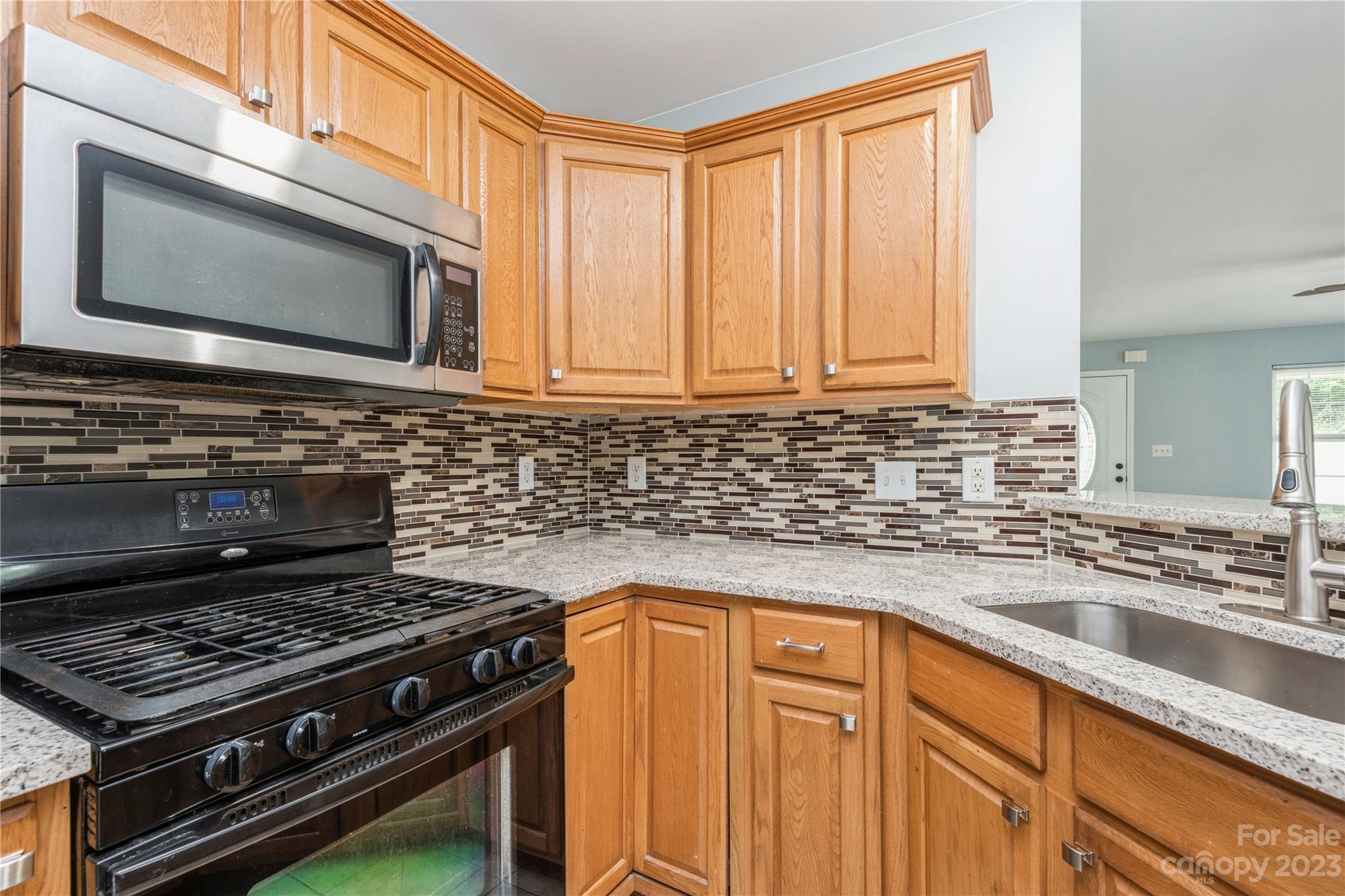 125 Rhyne Station Road Charlotte, NC 28214 - Photo 10 of 26 a kitchen with granite countertop a stove sink and microwave