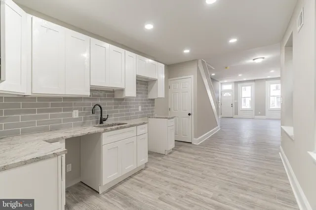 a view of a kitchen with a sink and wooden floor