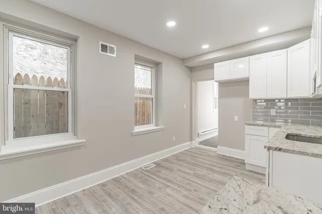 a view of a kitchen with wooden floor and a window