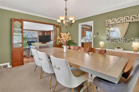 a dining room with furniture a chandelier and wooden floor