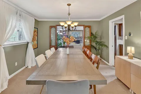 a living room with dining table furniture and a chandelier
