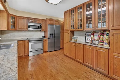 a kitchen with stainless steel appliances granite countertop a refrigerator and a stove top oven