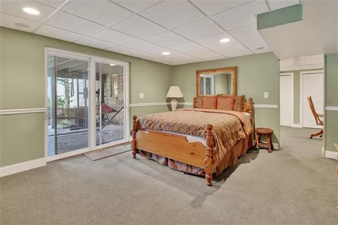 a bed sitting in a spacious bedroom next to a window