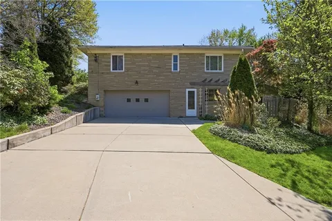 a front view of house with yard and trees in the background