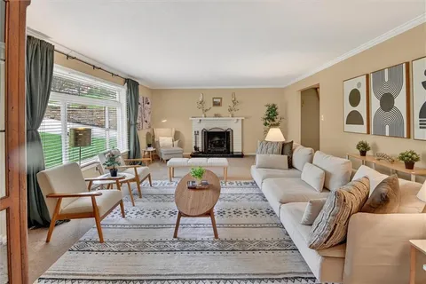 a living room with furniture large windows and a fireplace