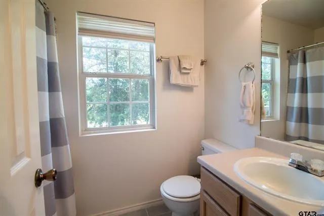 a bathroom with a sink a toilet and a window