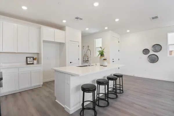 a kitchen with a table chairs sink and cabinets