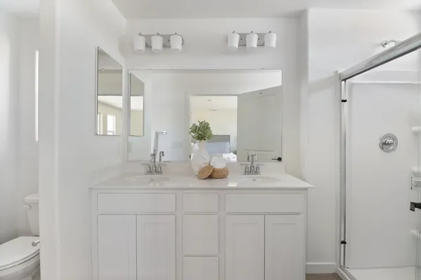a bathroom with a double vanity sink mirror and shower