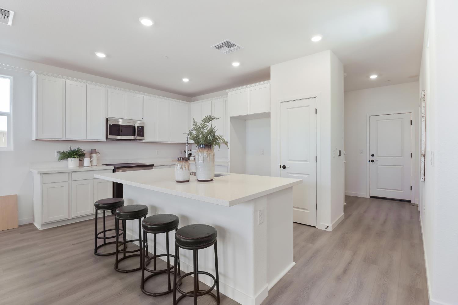 1108 Ashera Street Rocklin, CA 95765 - Photo 9 of 27 a kitchen with kitchen island granite countertop wooden floors and white cabinets