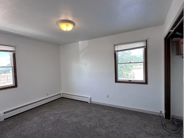 an empty room with windows and closet