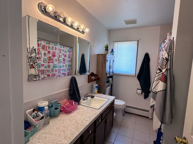 a bathroom with a sink vanity mirror and toilet