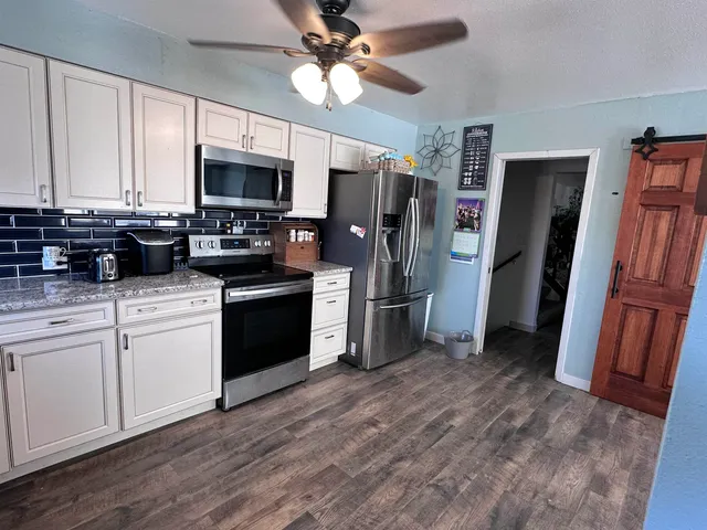 a kitchen with stainless steel appliances a refrigerator a stove a microwave and cabinets