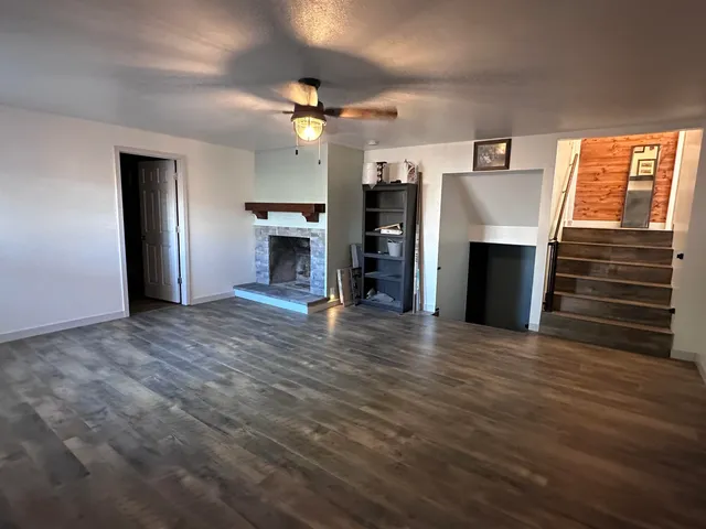 a view of an empty room with a fireplace and a window