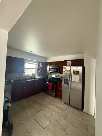 a kitchen with stainless steel appliances granite countertop a refrigerator and a stove