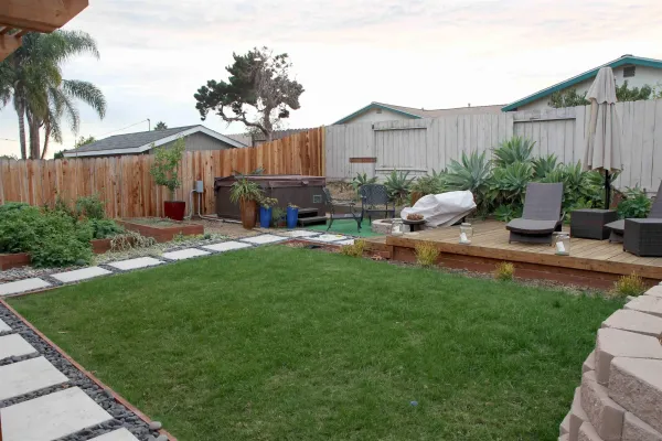 a view of a backyard with couches under an umbrella