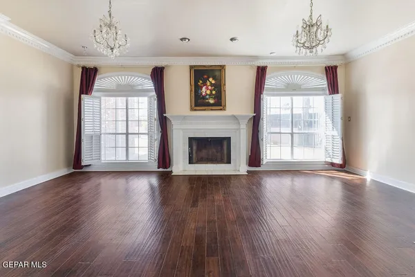 a view of a livingroom with a fireplace wooden floor and windows