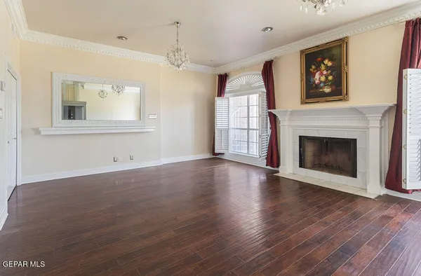 a view of an empty room with wooden floor and window