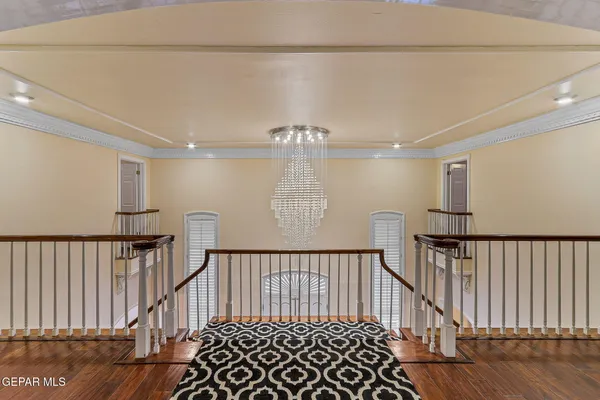 an empty room with wooden floor and windows with curtains