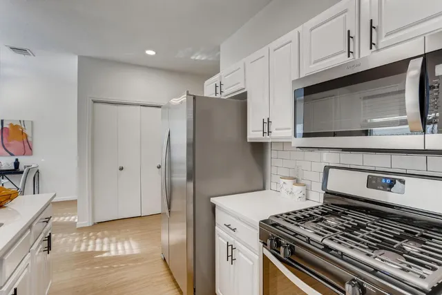 a kitchen with stainless steel appliances granite countertop a stove and a refrigerator
