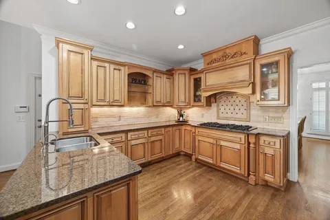 a kitchen with granite countertop stainless steel appliances stove top oven and cabinets