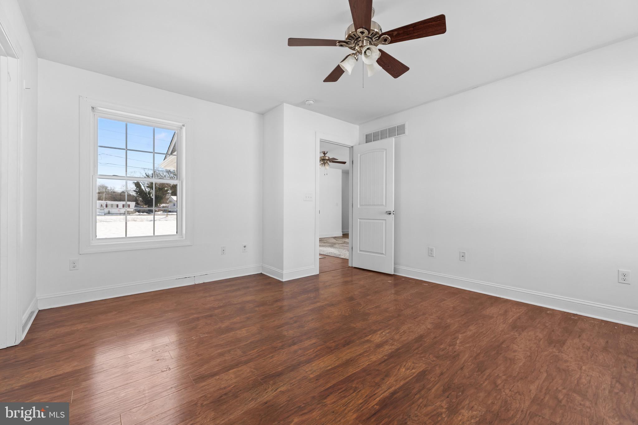 7180 Shawnee Road Milford, DE 19963 - Photo 12 of 20 a view of empty room with wooden floor and fan