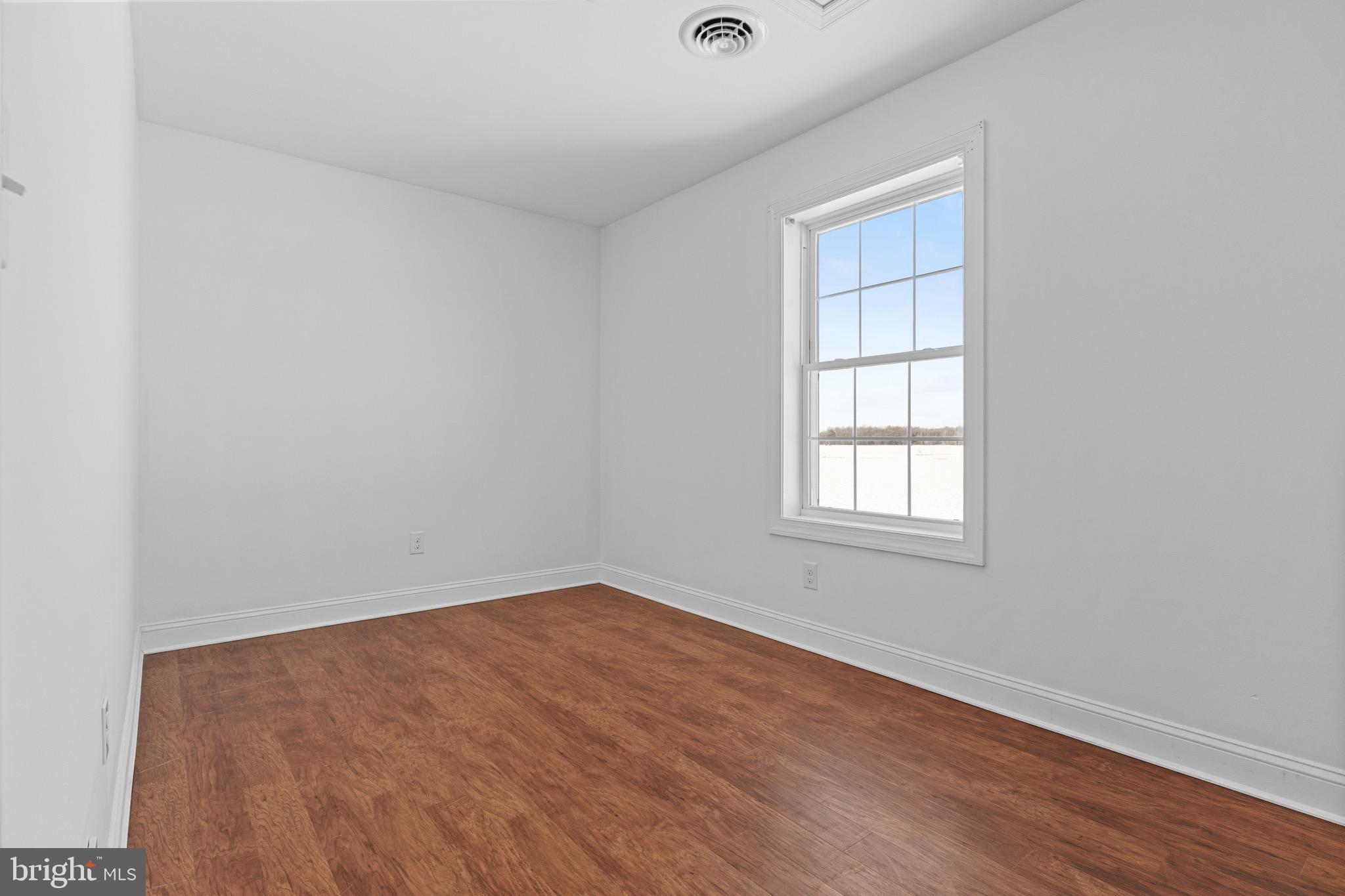 7180 Shawnee Road Milford, DE 19963 - Photo 14 of 20 an empty room with wooden floor and windows