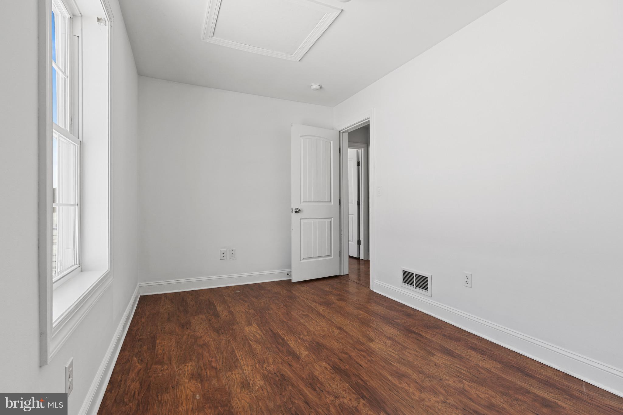7180 Shawnee Road Milford, DE 19963 - Photo 16 of 20 a view of an empty room with wooden floor and a window
