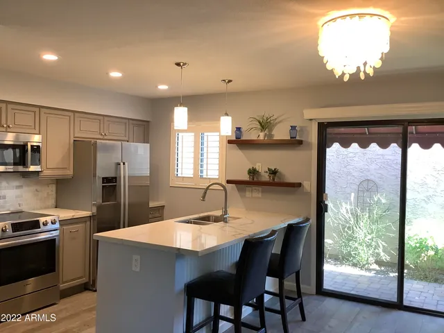 a kitchen with stainless steel appliances granite countertop a sink a stove and a refrigerator