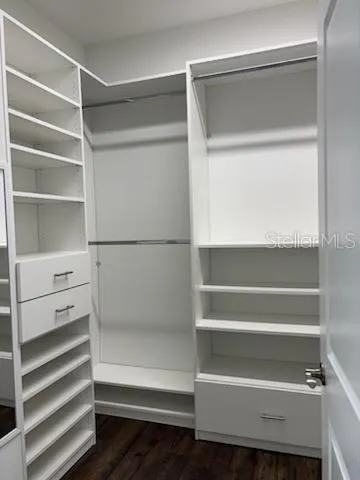 a view of walk in closet with empty racks