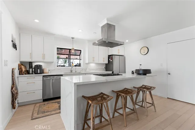 a kitchen with stainless steel appliances a sink a stove a refrigerator and cabinets