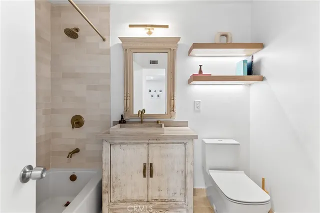 a bathroom with a granite countertop toilet sink and mirror