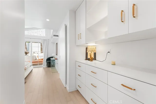 a hallway with a view of living room with furniture and mirror