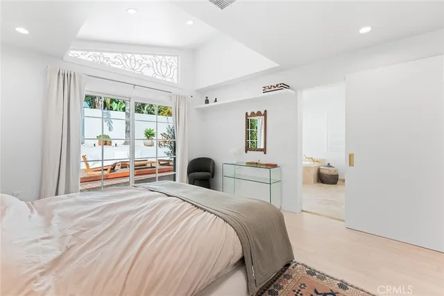 a bedroom with a bed and a large window