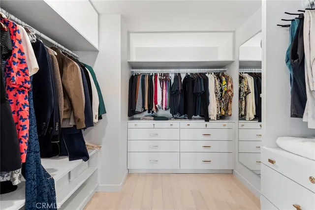 a view of walk in closet with clothes and shoes