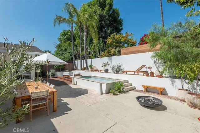 a view of a swimming pool with outdoor seating and plants