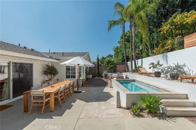 a view of a patio with couches table and chairs and potted plants