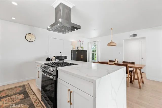 a kitchen with a stove a table and chairs