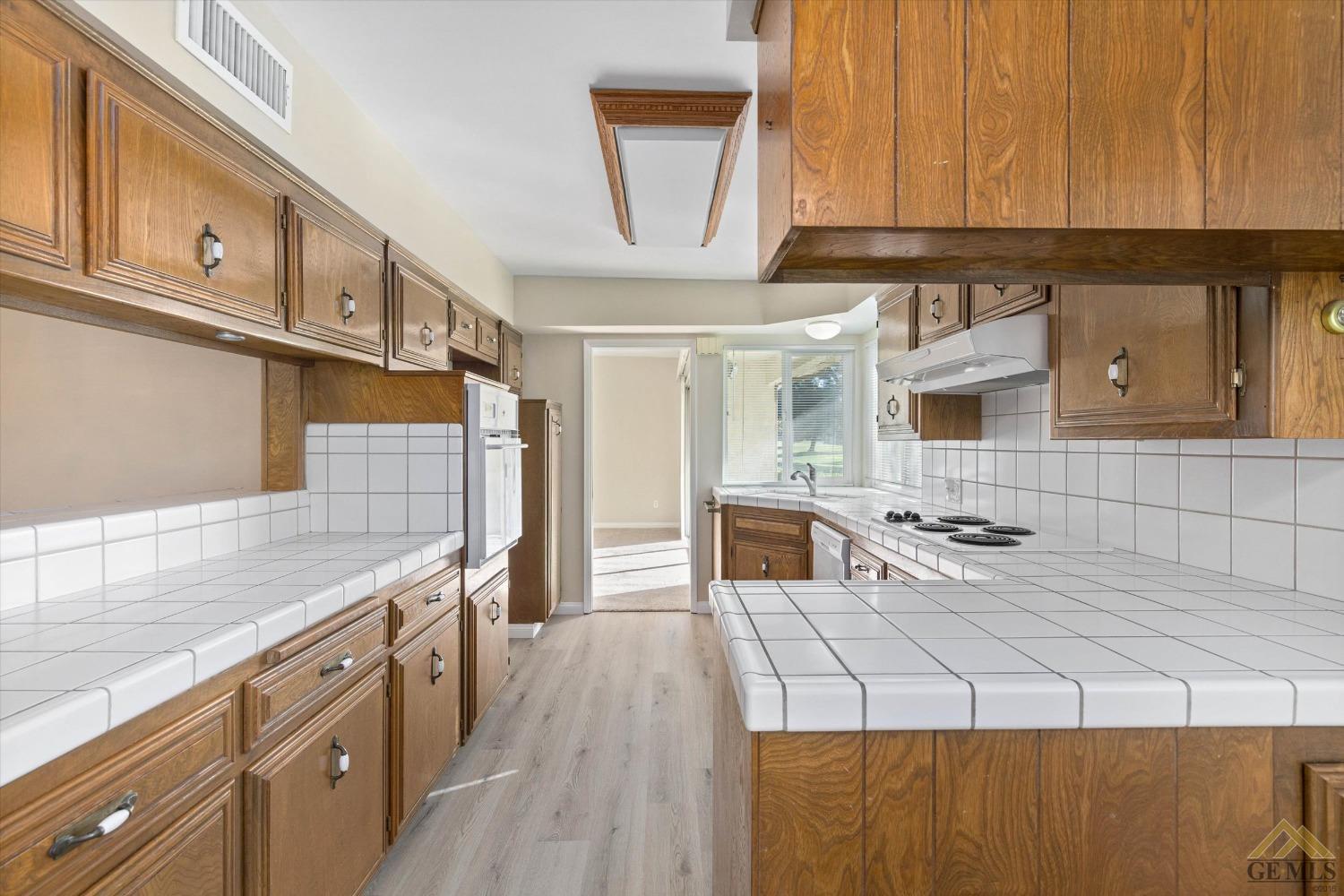 Undisclosed Address Bakersfield, CA 93309 - Photo 16 of 32 a kitchen with stainless steel appliances wooden cabinets a stove and a refrigerator