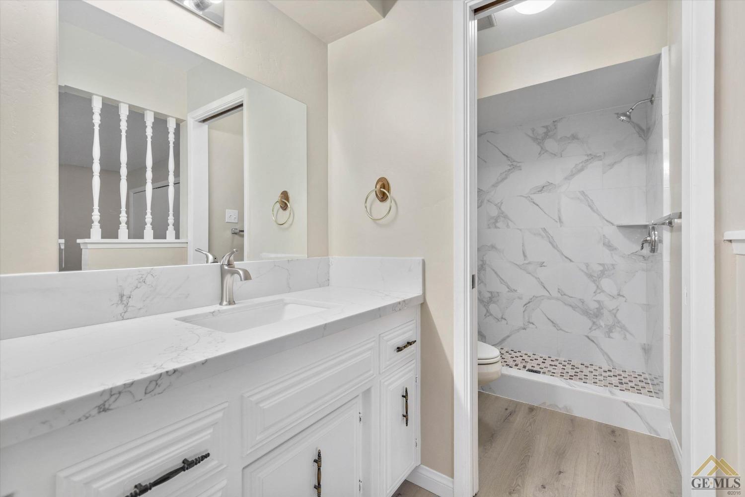 Undisclosed Address Bakersfield, CA 93309 - Photo 24 of 32 a bathroom with a granite countertop sink a mirror and a shower