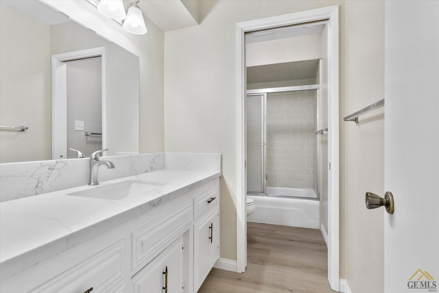 Undisclosed Address Bakersfield, CA 93309 - Photo 27 of 32 a bathroom with a granite countertop sink tub and a mirror