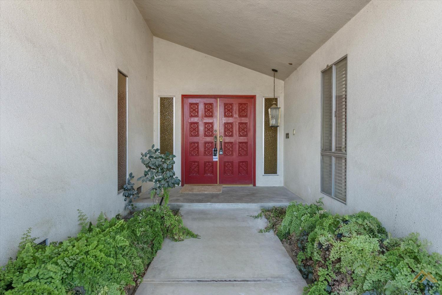 Undisclosed Address Bakersfield, CA 93309 - Photo 4 of 32 a front view of a house with a yard and flower plants
