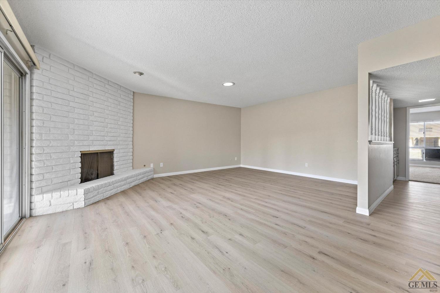 Undisclosed Address Bakersfield, CA 93309 - Photo 8 of 32 a view of an empty room with wooden floor fireplace and a window