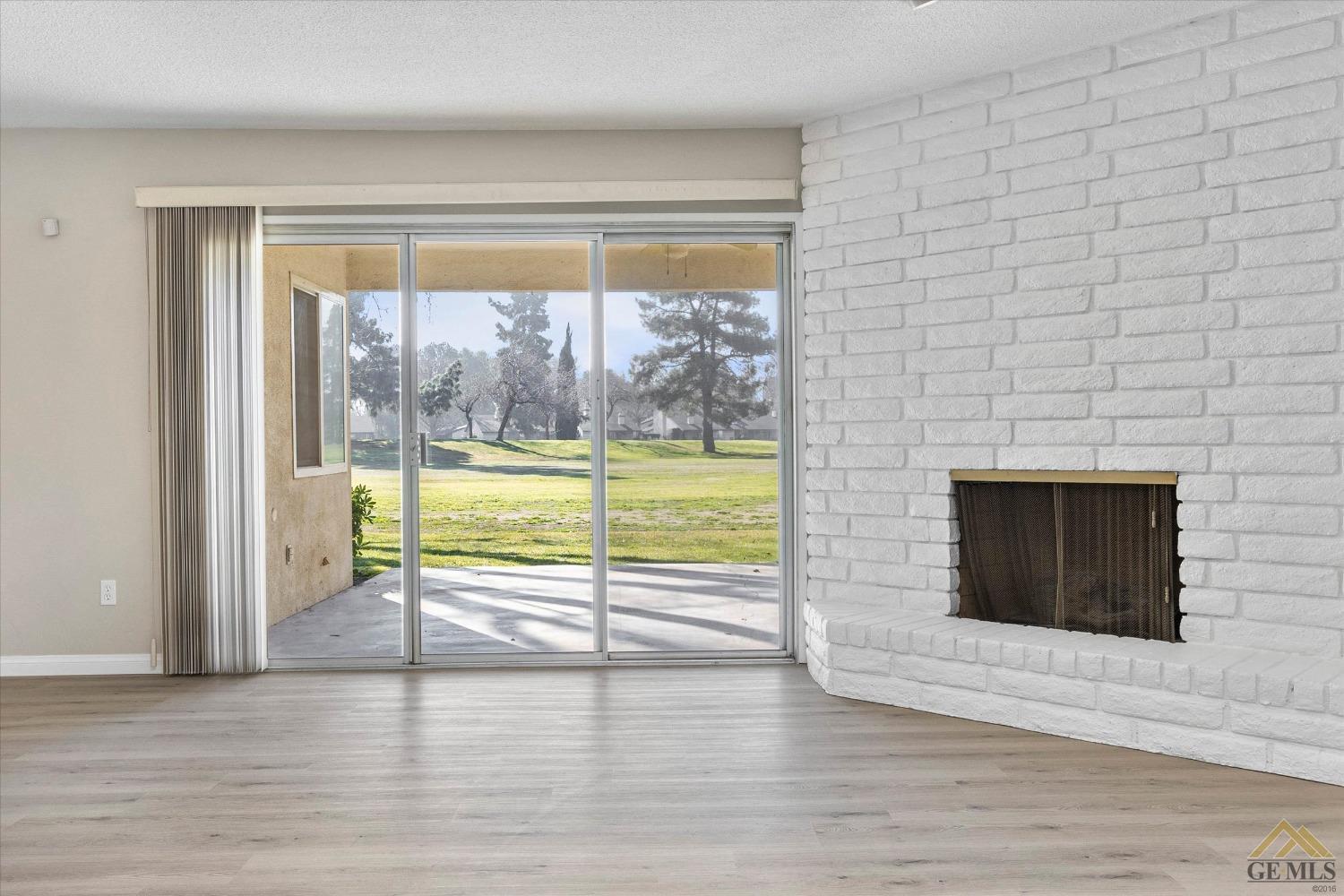 Undisclosed Address Bakersfield, CA 93309 - Photo 9 of 32 a view of an empty room with wooden floor and a fireplace