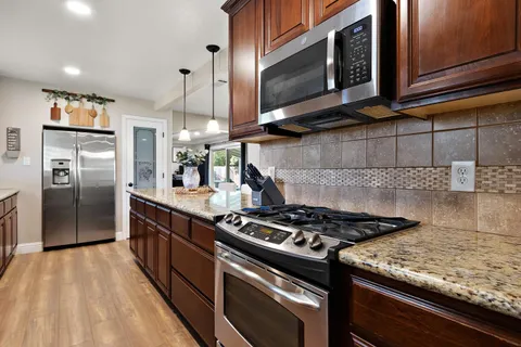 a kitchen with stainless steel appliances granite countertop a stove and a microwave