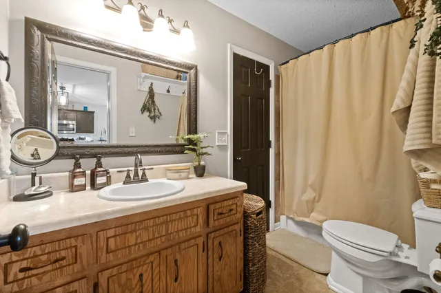 a bathroom with a double vanity sink mirror and toilet