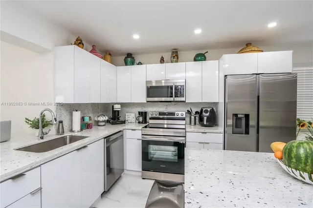 a kitchen with white cabinets and stainless steel appliances
